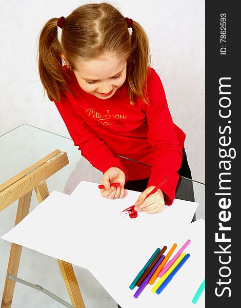 Young girl in red drawing an image. Isolated. Young girl in red drawing an image. Isolated.