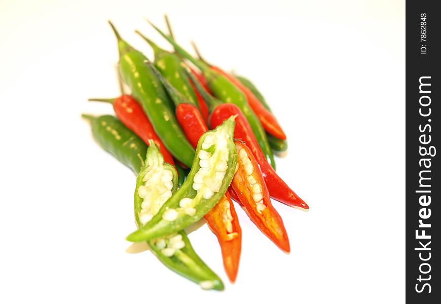 A pile of Green Finger Chillies and Bird Eye Chillies on a white background. A pile of Green Finger Chillies and Bird Eye Chillies on a white background