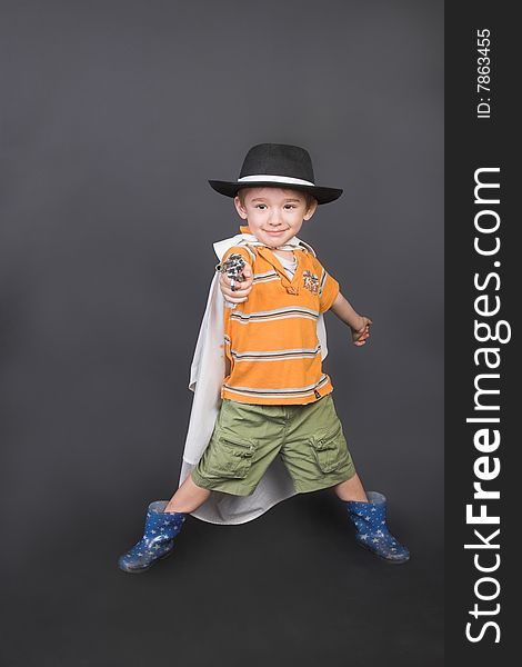 Young boy playing dressed up in hat and cape. Young boy playing dressed up in hat and cape