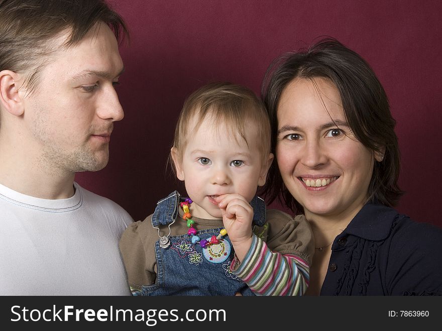 Portrait of father, mather and daughter on the purple background. Portrait of father, mather and daughter on the purple background