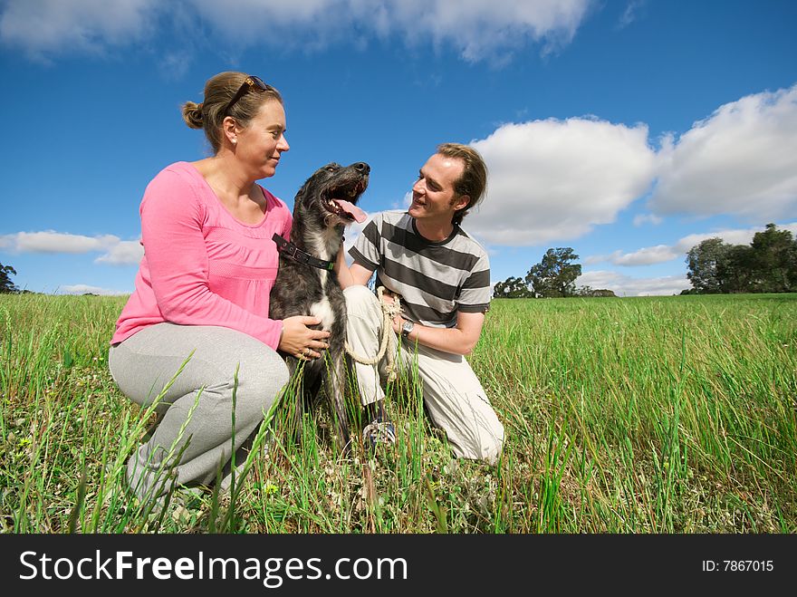 Couple with dog in field