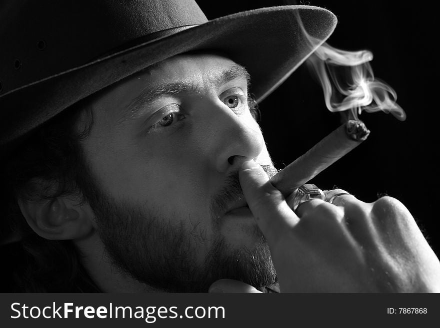 Stock photo: an image of a man in a hat with a cigar. Stock photo: an image of a man in a hat with a cigar