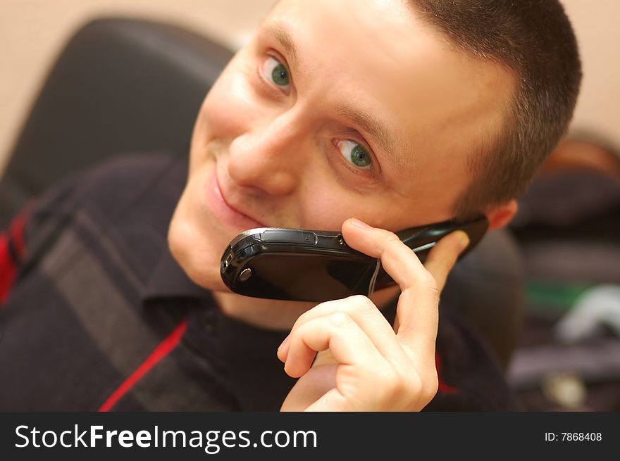 Young man speaks by mobile phone and smiling