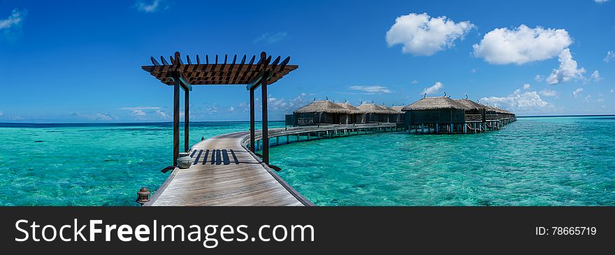 Amazing beautiful tropical beach panorama with wooden ocean water villas at Maldives