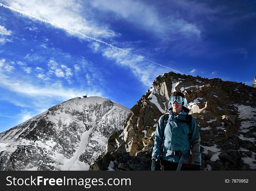 A young, female snowboarder on a treacherous hike below Lone Peak at Big Sky Resort. A young, female snowboarder on a treacherous hike below Lone Peak at Big Sky Resort.