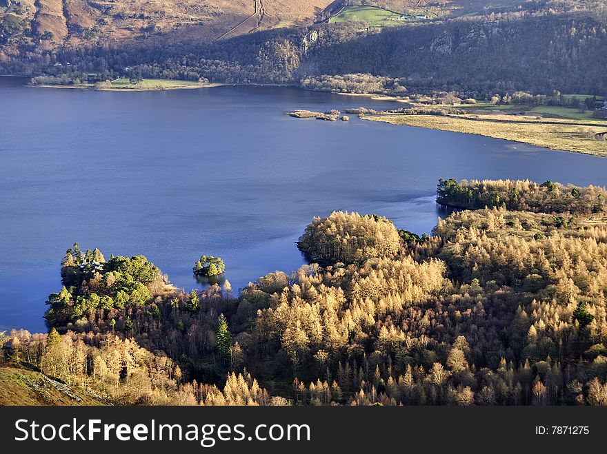 Aerial view across the Southern end of Derwent Water in the English Lake District with coniferous forest on the shore