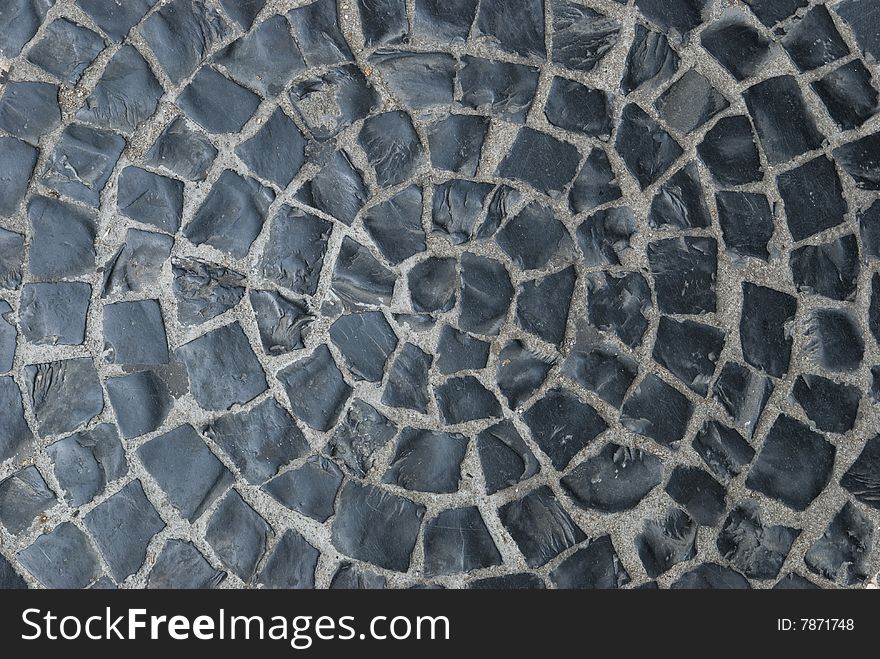 Black, old cobblestones in a circular shape. Black, old cobblestones in a circular shape.