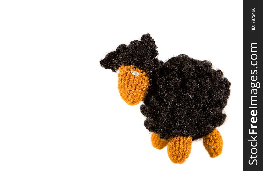 Isolated black and brown crocheted lamb on white