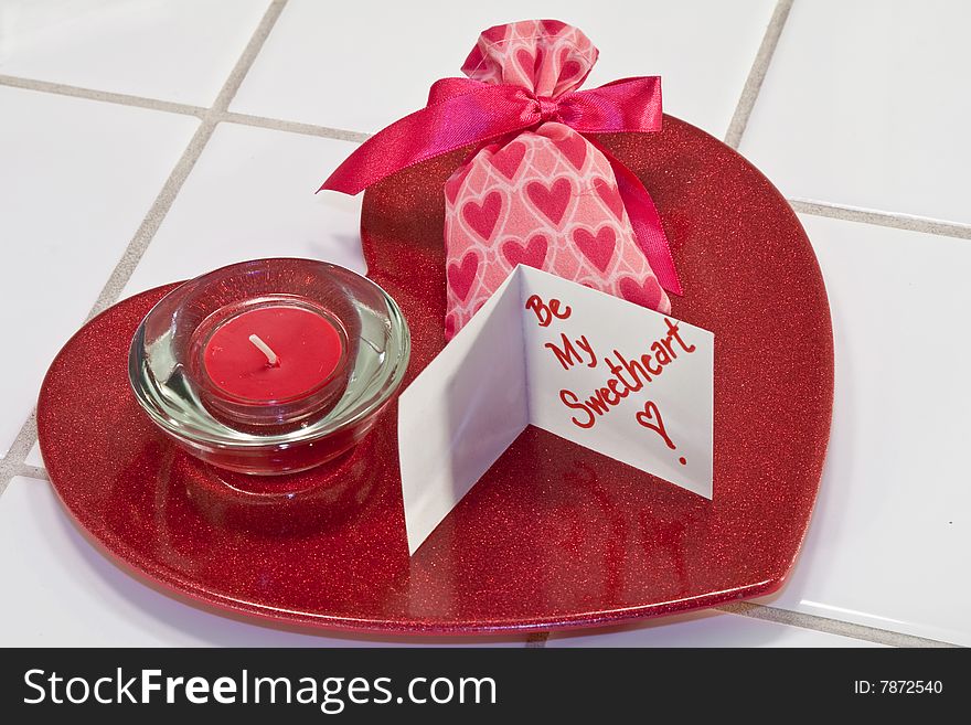 Red metallic heart dish with red candle in holder and valentine sachet with card. Red metallic heart dish with red candle in holder and valentine sachet with card