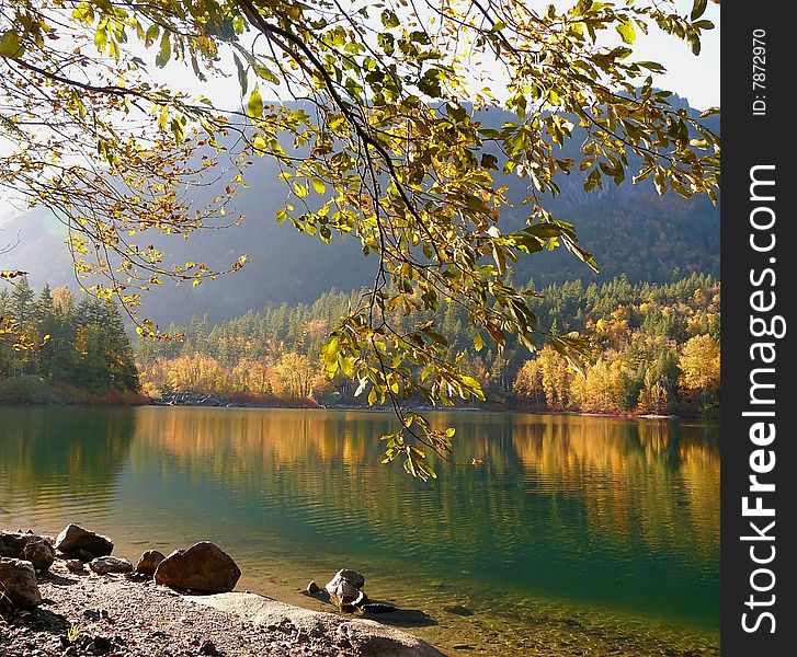 Autumn's natural beauty is reflected in a calm lake on a bright and sunny fall day. Autumn's natural beauty is reflected in a calm lake on a bright and sunny fall day.