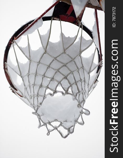 Basketball net full of snow after a whole snowy day. Focus on the net. Basketball net full of snow after a whole snowy day. Focus on the net.