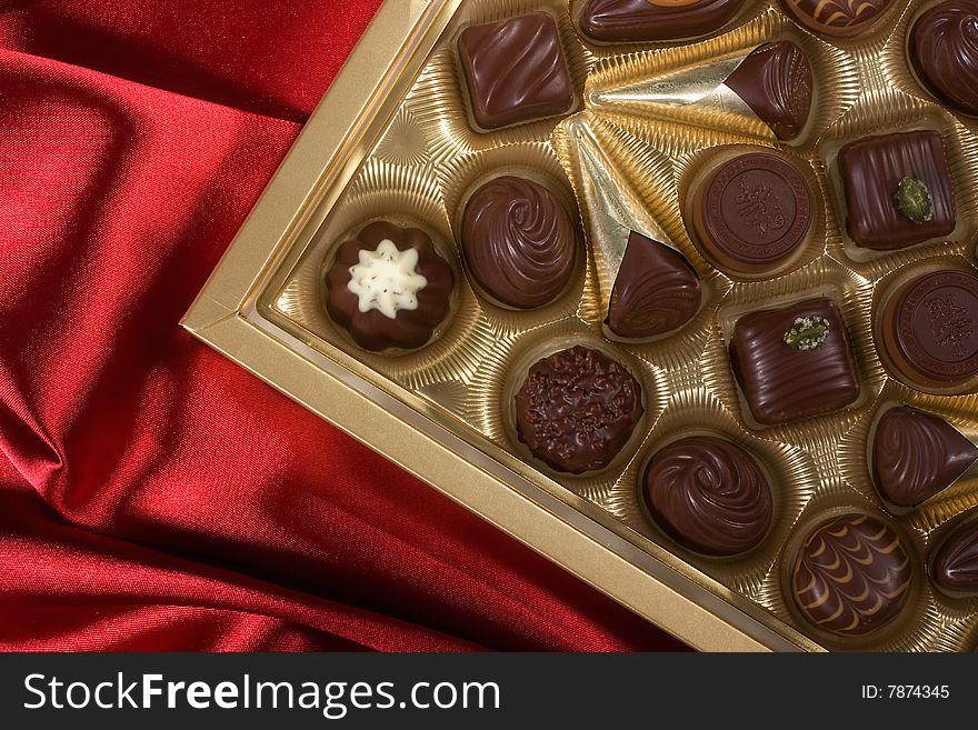 Golden chocolates box on red satin background