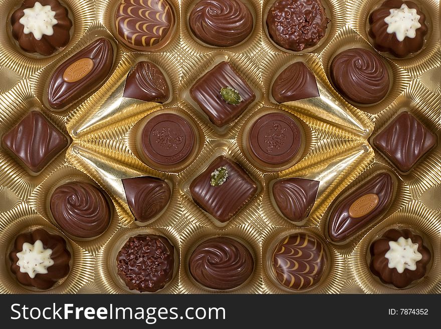 Closeup on a box of chocolates in gold colored tray. Closeup on a box of chocolates in gold colored tray.