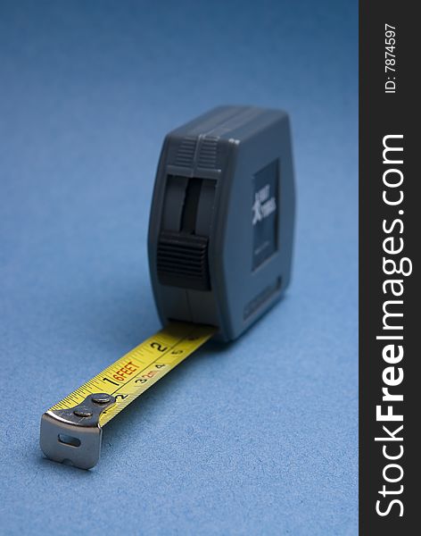 Tape measure with imperial and metric markings on contrasting blue background.