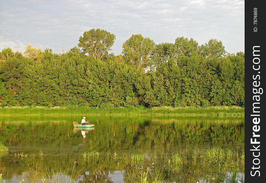 Fishing on lake from a boat at green coast