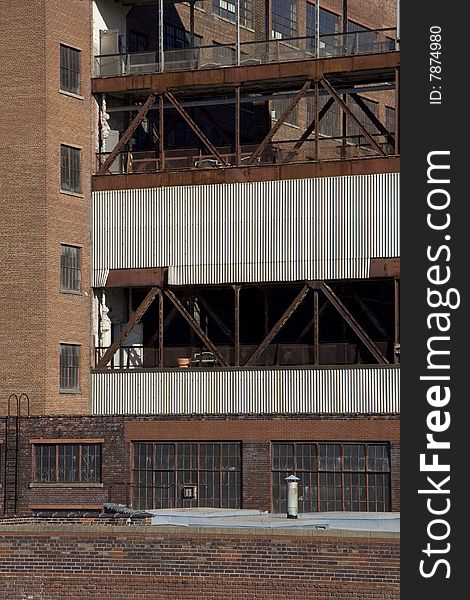 A detail shot of an old and badly maintained industrial building. Some of the windows are cracked. A detail shot of an old and badly maintained industrial building. Some of the windows are cracked.