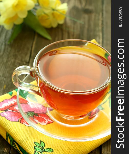 Cup of tea and flowers on old wooden background
