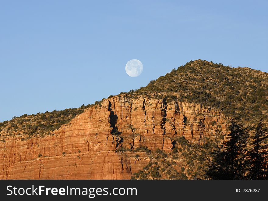 The moon setting over the red mountains of Sedona