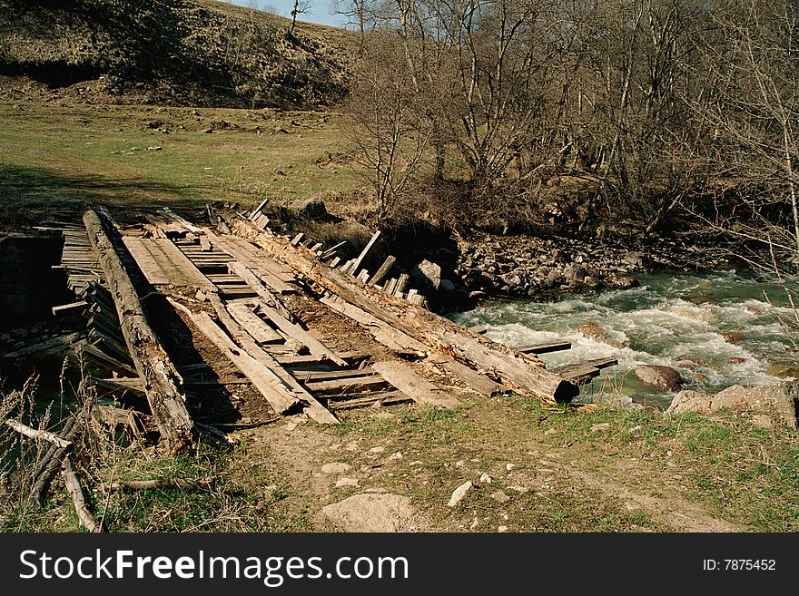 This picture shows wooden bridge across Aksaut river on the North Caucasus. The bridge is pretty old and seems to be ramshackle. This picture shows wooden bridge across Aksaut river on the North Caucasus. The bridge is pretty old and seems to be ramshackle.