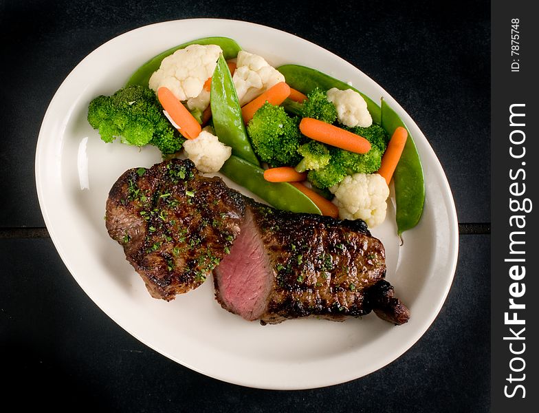 Medium rare, seared steak with steamed vegetables. Medium rare, seared steak with steamed vegetables