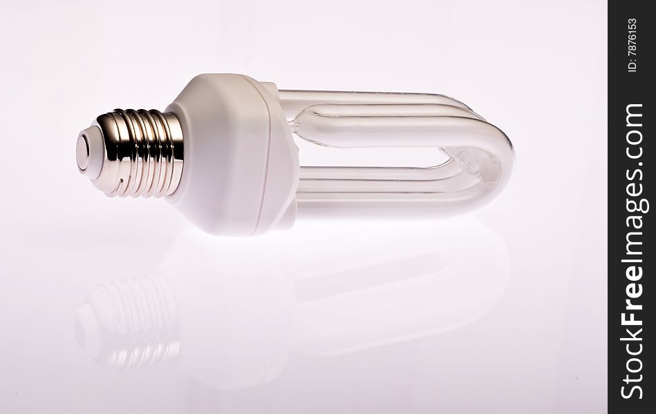 Fluorescent energy-saving lamp on white background with reflection