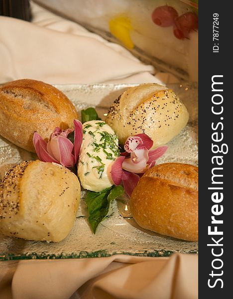 An image of oven baked sourdough rolls with chive butter and orchids. An image of oven baked sourdough rolls with chive butter and orchids