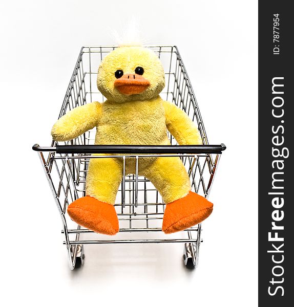 Plush toy duck sitting in a metal shopping cart. Plush toy duck sitting in a metal shopping cart.