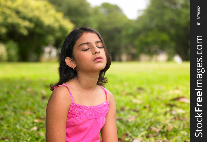 Asian girl sitting in the park on the grass