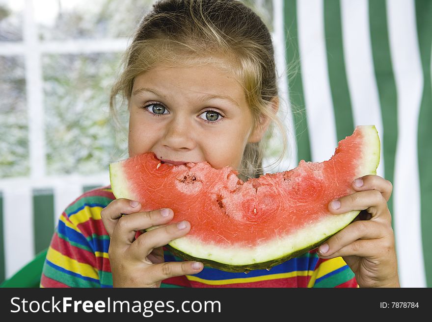 Little blond girl with a piece of watermelon in her hands. Little blond girl with a piece of watermelon in her hands