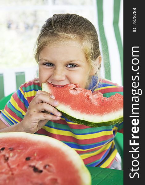 Little blond girl with a piece of watermelon in her hands. Little blond girl with a piece of watermelon in her hands