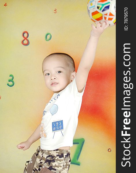 The boy`s eyes are sparkling,his left hand holding a ball and put it high upã€‚. The boy`s eyes are sparkling,his left hand holding a ball and put it high upã€‚