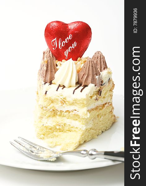 A slice of a cream cake and red heart. A slice of a cream cake and red heart.