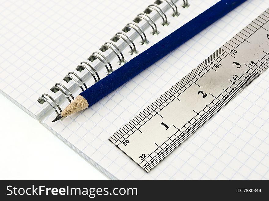Pencil and ruler on the blank spiral notepad