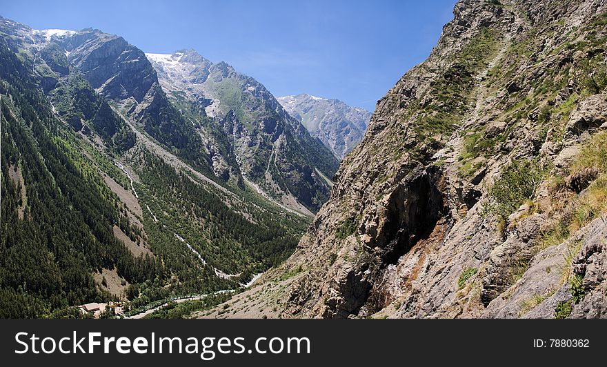 A panoramic view on rocky mountains under clear sky with green and rocky slopes. Alpes, Switzerland, europe. XXL size. A panoramic view on rocky mountains under clear sky with green and rocky slopes. Alpes, Switzerland, europe. XXL size.