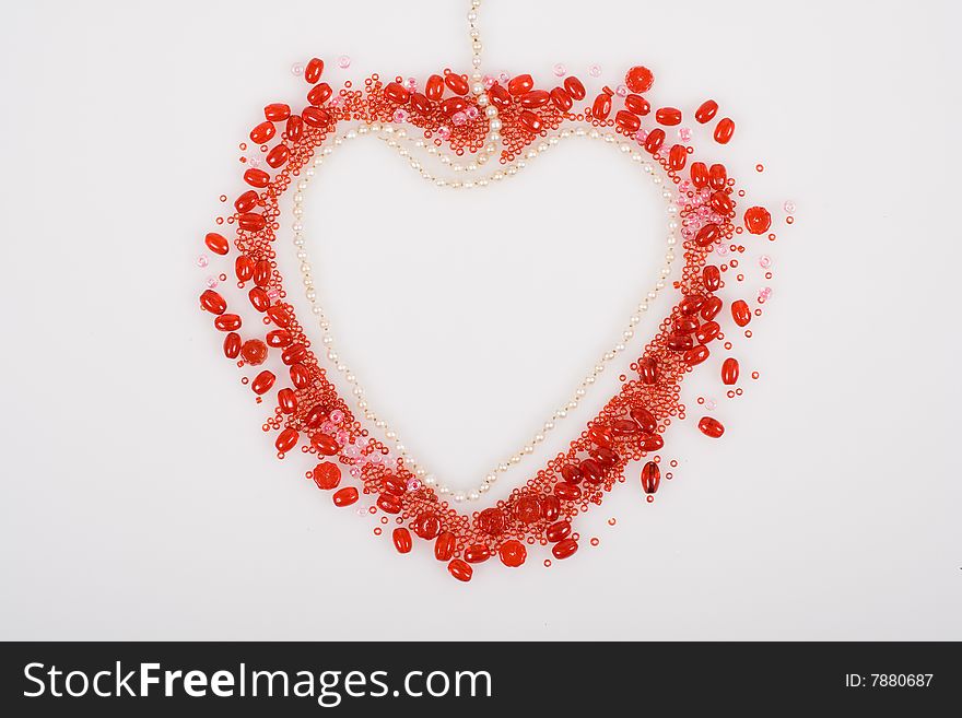 Red heart made with beads and pearls isolated on white background