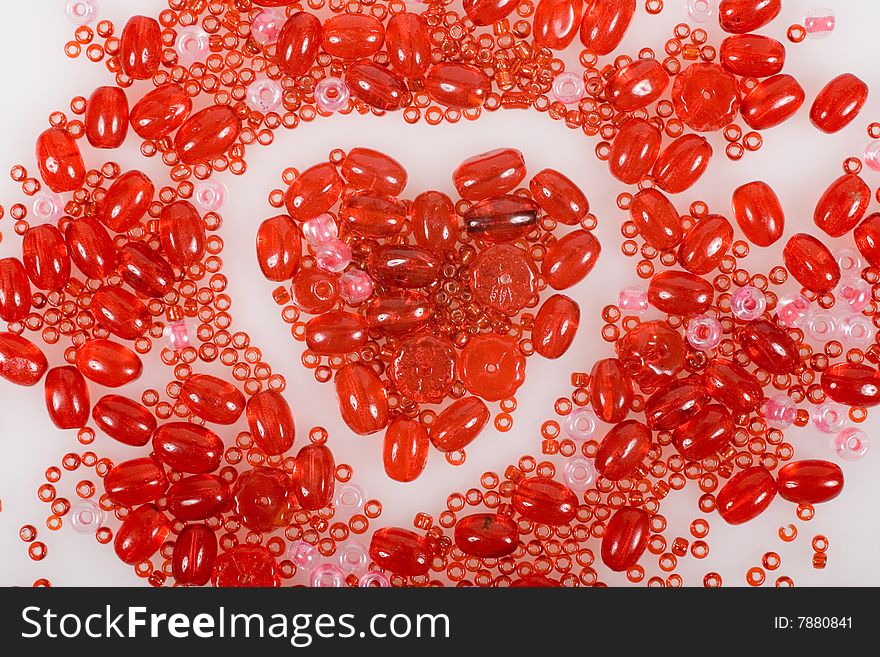 Heart made with red beads isolated on white background