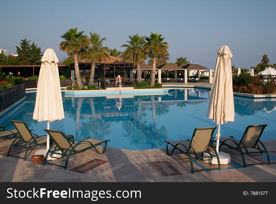 Couch and sunshade near of a swimming pool in resort