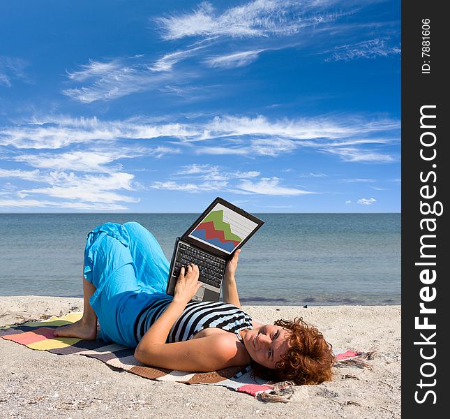 Girl working on laptop near of sea