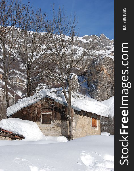 An isolated chalet during a strong cold winter in italian alps. An isolated chalet during a strong cold winter in italian alps