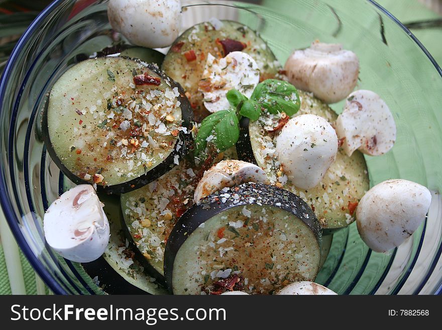 Fresh vegetables like aubergines and mushrooms with basil