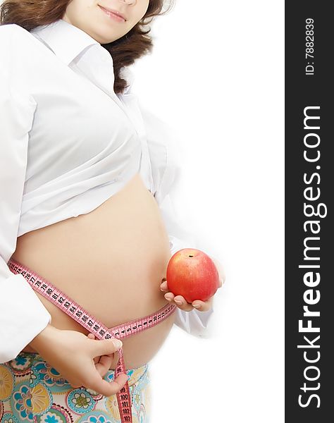 Woman holding pregnant belly with measuring tape and red apple. Woman holding pregnant belly with measuring tape and red apple