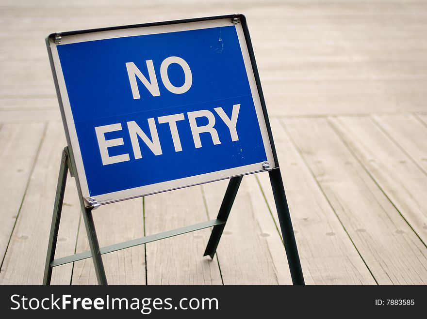 A no-entry sign board on the wooden deck. A no-entry sign board on the wooden deck.