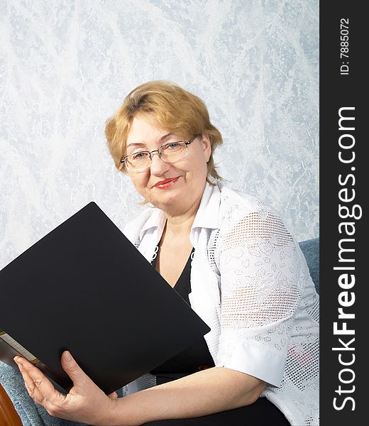 The business mature woman with a folder in hands. The business mature woman with a folder in hands