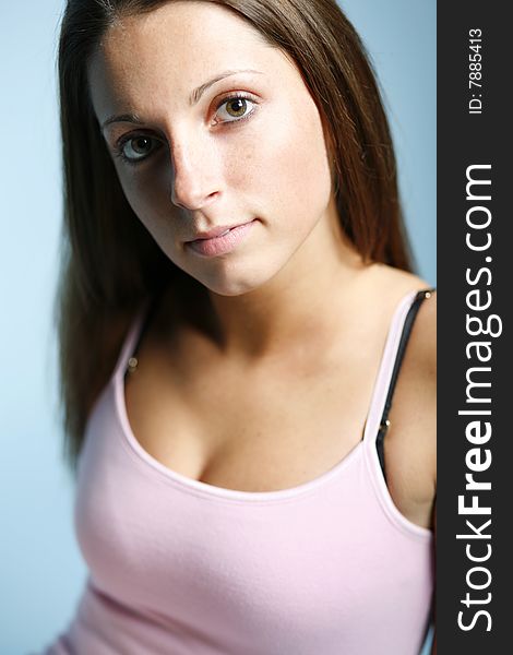 Portriat of a young woman wearing a pink tank top with shadow across half of her face. Portriat of a young woman wearing a pink tank top with shadow across half of her face.