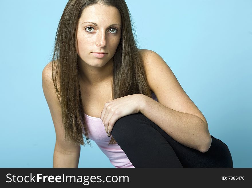 Cute young woman sitting down with hand on knee. Cute young woman sitting down with hand on knee.