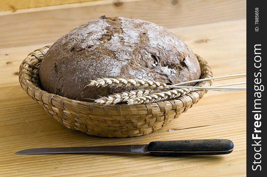 Bread and corn and knife on wooden desk