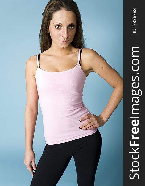 Nineteen year old shows off her exercise outfit set against blue backdrop.