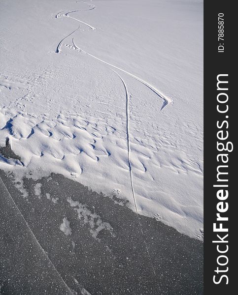 Skating tracks in snow covering a frozen lake on a sunny winter day. Skating tracks in snow covering a frozen lake on a sunny winter day.