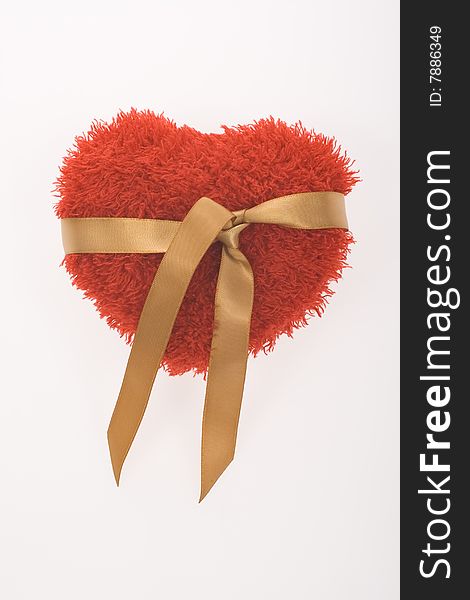 Red fluffy heart with golden ribbon on white background