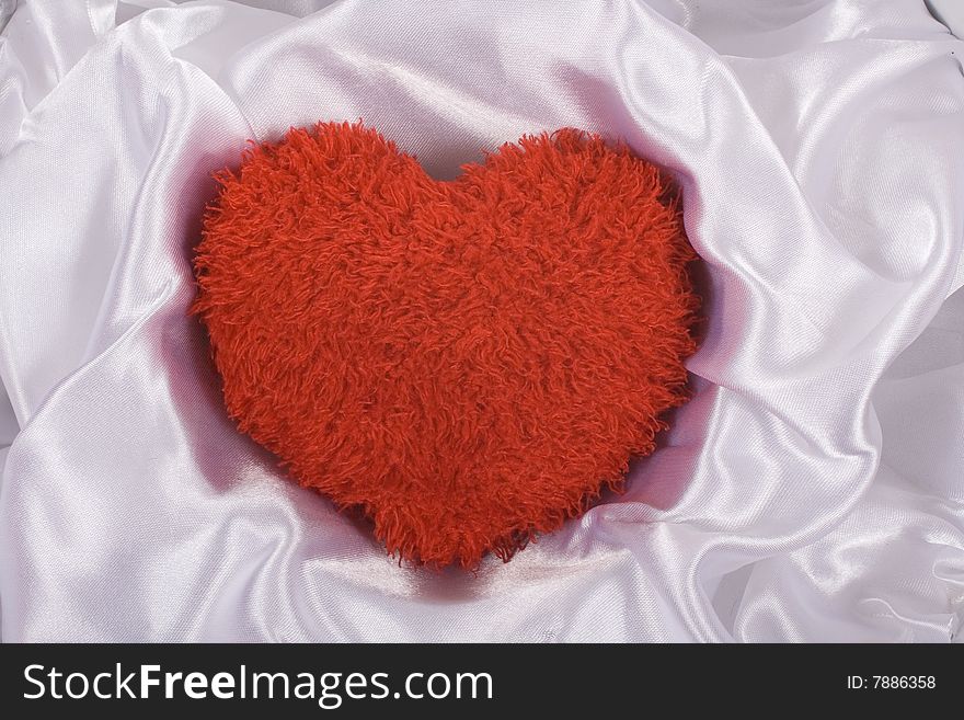 Red fluffy heart on satin white background